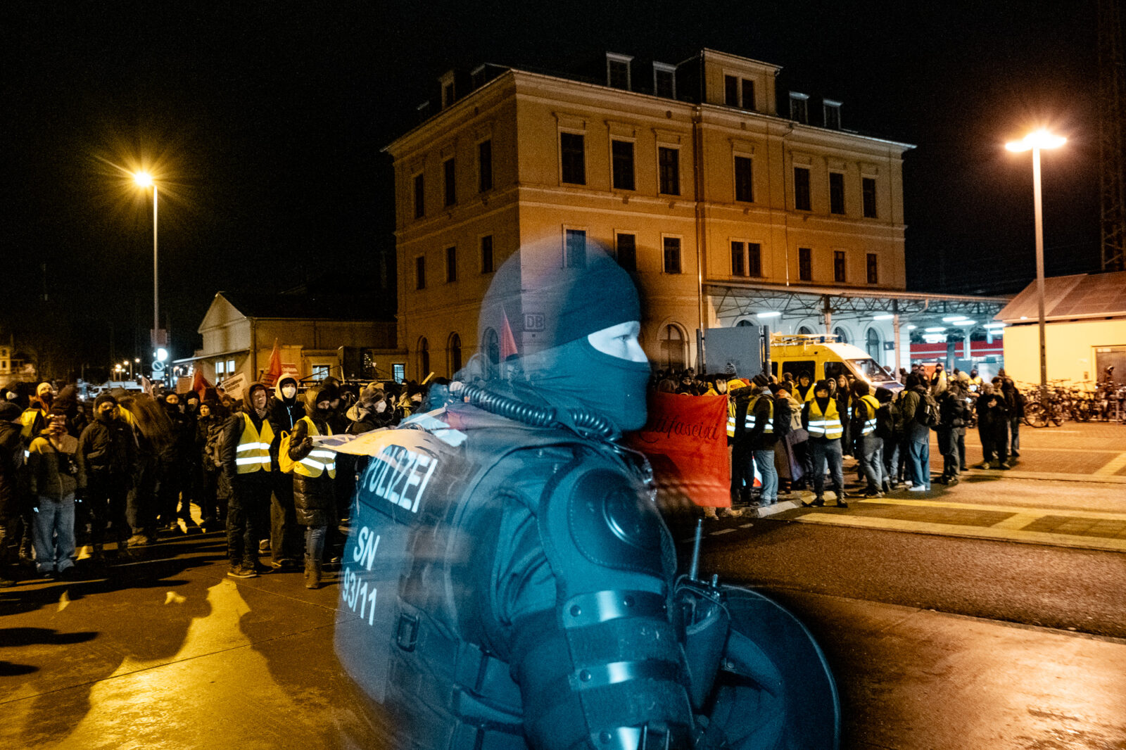 Menschenmenge mit Polizist in der Dämmerung