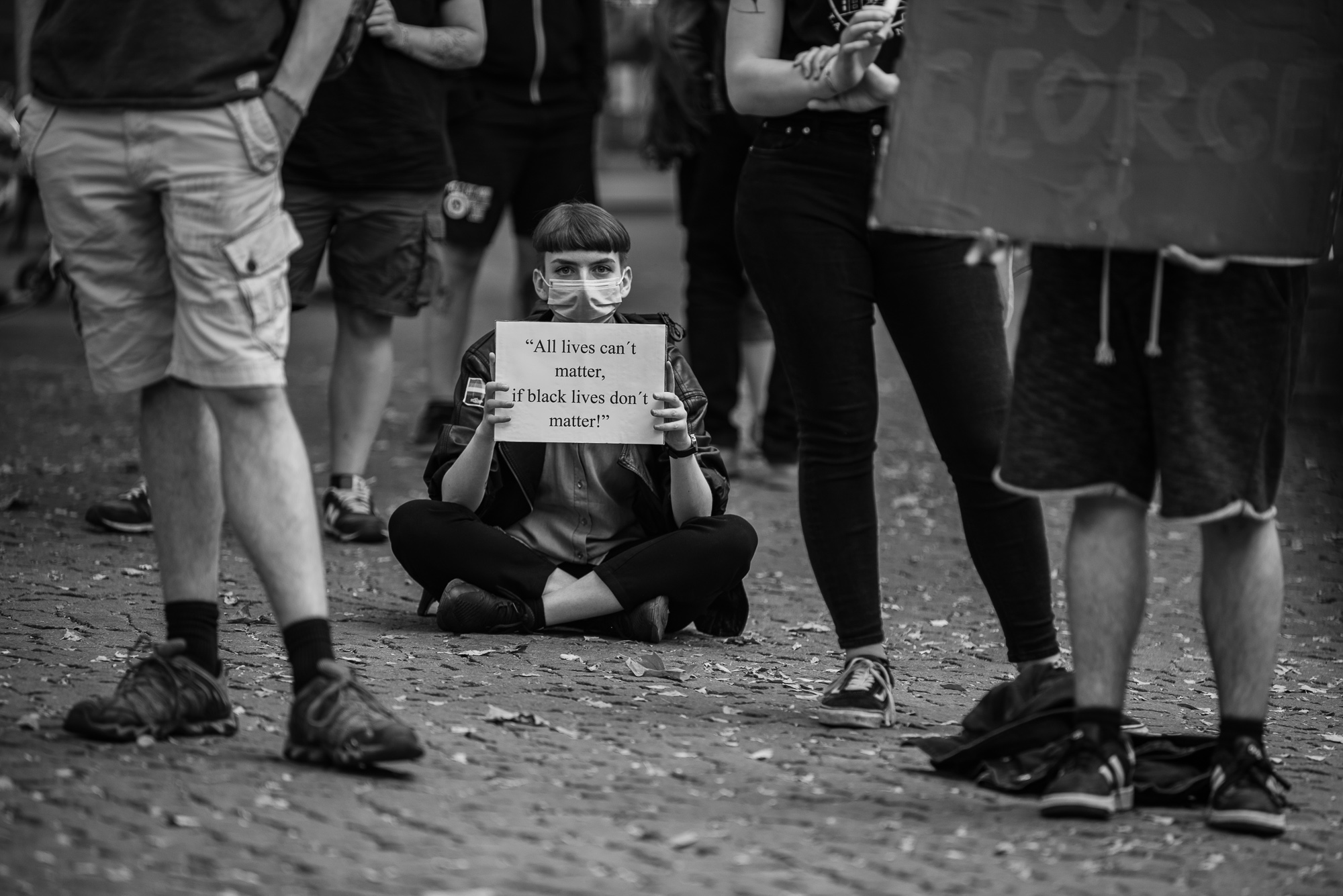 BlackLivesMatter - München - sitzende Frau mit Schild